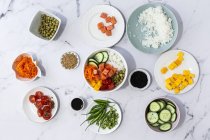 Top view of assorted fresh ingredients for traditional oriental poke preparation placed on marble tabletop — Stock Photo