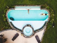 Top view couple in a swimming pool enjoying a sunny summer day — Stock Photo