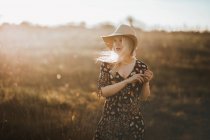 Retrato de uma bela jovem mulher com chapéu no campo olhando para longe — Fotografia de Stock