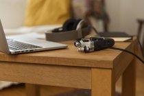 Gravador de áudio e fones de ouvido colocados em mesa de madeira com laptop e notebook para gravação de podcast em casa — Fotografia de Stock