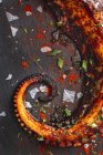 Сверху вкусные щупальца осьминога со специями на деревянной доске — стоковое фото