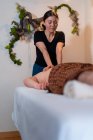 Terapeuta feminina fazendo massagem tailandesa para cliente masculino deitado na mesa no salão de spa — Fotografia de Stock