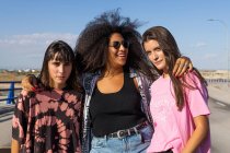Three beautiful young women of different races with their long board boards and smiling — Stock Photo