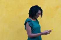 Портрет молодой женщины, отправляющей сообщение со смартфона на улице. — стоковое фото