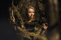 Retrato de jovem bela mulher loira em uma floresta, iluminação dramática em seu rosto — Fotografia de Stock