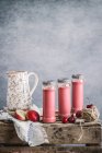 Milkshake rinfrescante con nettarine e ciliegie servito in bicchieri su tavolo di legno con fiori — Foto stock