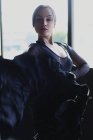 Joven mujer elegante en negro llevar baile flamenco con los brazos levantados mientras mira a la cámara - foto de stock