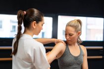 Female osteopath fitting shoulder join of patient in pain during physiotherapy session — Stock Photo