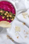Von oben appetitanregender Rote-Bete-Hummus garniert mit Kichererbsen, serviert auf Stoffhintergrund mit Brot — Stockfoto