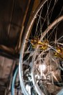 Par en bas des jantes de vélo brillantes métalliques suspendues sur le rack dans le service de réparation — Photo de stock