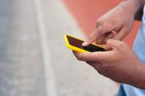 Homme noir utilisant un téléphone intelligent contre un mur rouge — Photo de stock