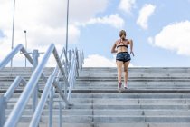 Mulher irreconhecível treinando para subir escadas ao ar livre, visão traseira — Fotografia de Stock