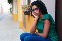 Retrato da bela mulher negra sentada na rua. Conceito urbano. — Fotografia de Stock