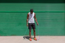Athlète masculin afro-américain concentré sautant à la corde pendant l'entraînement cardio par une journée ensoleillée en ville — Photo de stock