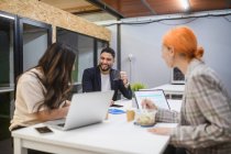 Gruppo di colleghi focalizzati seduti a tavola e che lavorano insieme al progetto startup nello spazio di coworking — Foto stock