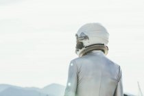 Back view man in spacesuit and helmet looking away while standing on path on sunny day in nature — Stock Photo