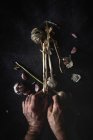 Dall'alto ritagliato mani persona irriconoscibile organizzare bouquet di spicchi d'aglio viola freschi collocati in fondo scuro — Foto stock
