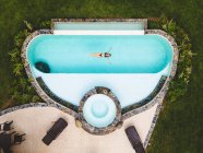 Top mulher vista sozinha em uma piscina desfrutando de um dia ensolarado de verão — Fotografia de Stock