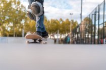 Кукурудзяний підліток ковзаняр стоїть на скейтборді і готується до показу трюку на пандусі в скейт-парку — стокове фото