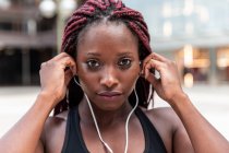Muskulöse ethnische Frau hört Musik — Stockfoto