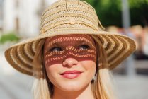 Вид збоку чарівна жінка в солом'яному капелюсі дивиться в сонячний день на міській вулиці влітку — стокове фото