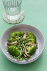 Primer plano visto desde arriba de un plato de verduras con brócoli, champiñones y guisantes - foto de stock