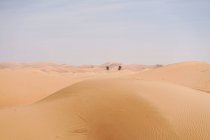 Минималистичный пустынный пейзаж с песчаными дюнами и ясным голубым небом в Эмиратах — стоковое фото