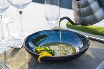 Офіціант поливає сочевичний суп у ресторані високої кухні — стокове фото