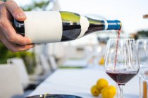 Kellner schenkt in gehobenem Restaurant Rotwein im Glas ein — Stockfoto
