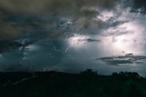 Cielo tempestoso di fulmini tra le nuvole scure e drammatiche — Foto stock