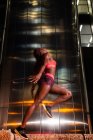 Етнічна спортсменка стрибає на вулиці вночі — стокове фото