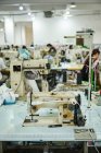 Detail einer alten Nähmaschine in einer geschäftigen chinesischen Schuhfabrik — Stockfoto