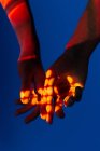 Imagen artística de un par de manos mostrando amor bajo las luces del proyector - foto de stock