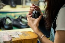 Dettaglio delle mani della donna mentre controlla le scarpe nella linea di produzione di controllo di qualità nella fabbrica di scarpe cinese — Foto stock