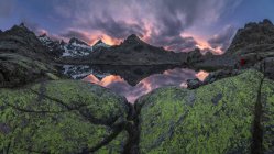 Lac Laguna Grange avec eau calme situé dans Circo de Gredos cirque entouré de crête de montagne enneigée contre ciel nuageux au coucher du soleil à Avila, Espagne — Photo de stock