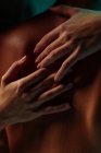 Woman hands embracing a man back under color lights — Stock Photo