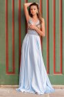 Повне тіло чарівної молодої жіночої моделі в елегантній модній блакитній вечірній сукні, що стоїть біля входу у старі будівлі і дивиться на камеру — стокове фото