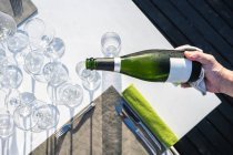 Camarero que sirve champán en una copa en el restaurante de alta cocina al aire libre - foto de stock