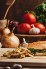 Аппетитные гамбургеры с овощами помещены на деревянную доску с картошкой фри на кухне — стоковое фото