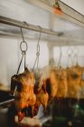 Prepared delicious appetizing roast duck hanging in cuisine in restaurant — Stock Photo
