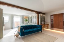 Інтер'єр вітальні сучасного затишного будинку з блакитним диваном — стокове фото