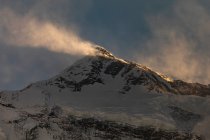 Montañas rocosas del Himalaya cubiertas de nieve iluminadas por la luz del sol en Nepal - foto de stock