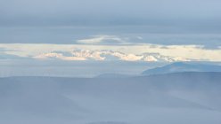 Paesaggio tranquillo con catena montuosa coperta di nebbia contro il cielo nuvoloso mattutino nel Parco Nazionale di Guadarrama a Madrid, Spagna — Foto stock