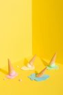 Mockup blue, yellow and pink melting ice cream in waffle cone placed on yellow background representing summer concept — Stock Photo