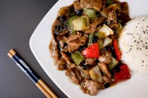Top view of dish with beef in delicious oyster sauce and chopsticks in restaurant — Stock Photo