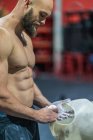 Muscular barbudo cara em sportswear espalhando pó durante o treino de musculação no ginásio — Fotografia de Stock