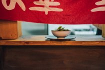 Plato asiático tradicional en tazón de cerámica blanca en ventana de madera en restaurante - foto de stock