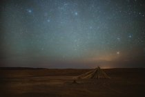 Strahlender Sternenhimmel über der friedlichen Wüste und schäbige Unterkünfte in der Nacht in Marrakesch, Marokko — Stockfoto