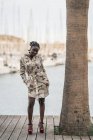 Stilvolle nachdenkliche schöne Afroamerikanerin mit afrikanischen Zöpfen, die im Park ernsthaft in die Kamera schaut — Stockfoto