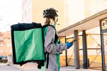 Frohe Zustellerin mit eingepackten Kartons und GPS-Karte auf dem Handy, während sie an sonnigen Tagen auf der Straße steht — Stockfoto